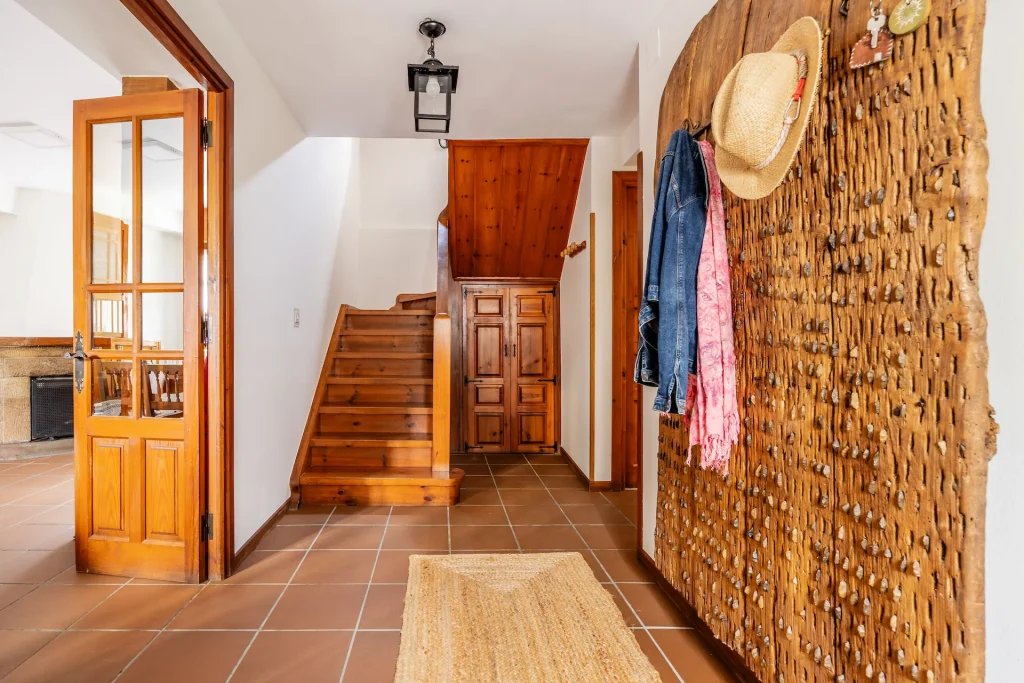 Entrada con la pieza singular que da personalidad a la casa. Un trillo transformado en perchero